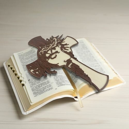 Open Bible with a cross-shaped artwork on top.