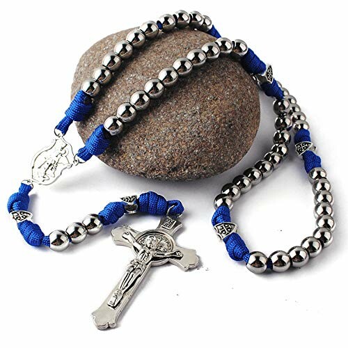 Blue and metal rosary with cross placed on a stone.