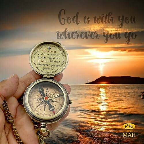 Hand holding compass with inspirational text at sunset over water.