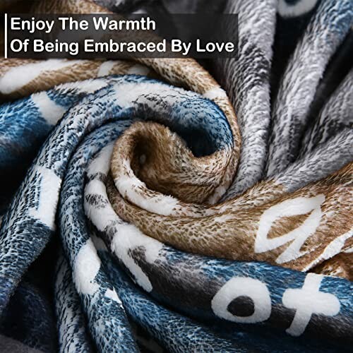 Close-up of a soft, colorful blanket with text 'Enjoy The Warmth Of Being Embraced By Love'.
