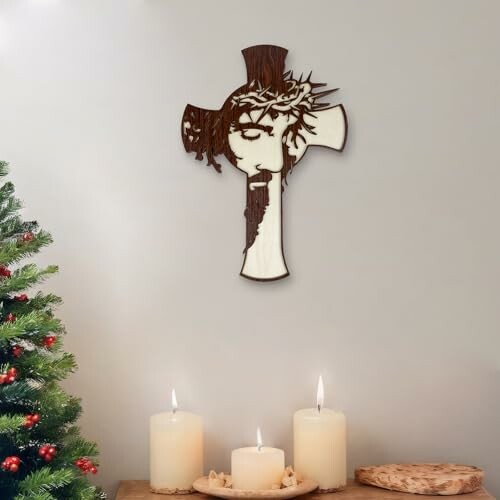 Wall art of Jesus on a cross with candles and a Christmas tree.