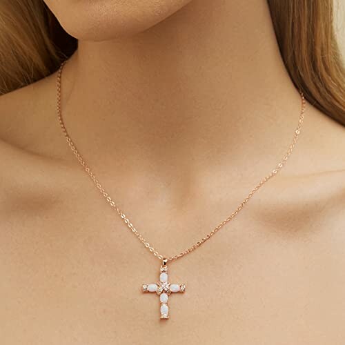 Woman wearing a gold chain with a cross pendant.