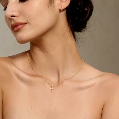 Woman wearing a gold cross necklace.