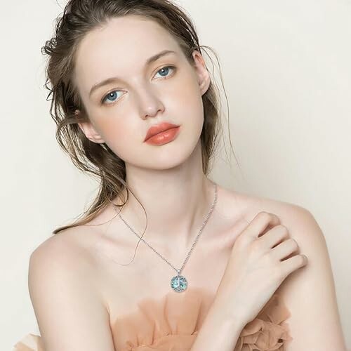 Woman wearing a necklace with a light background.