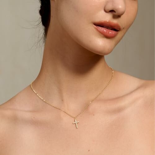 Woman wearing a gold cross necklace.