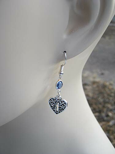 Silver heart-shaped earring with gemstone on mannequin.