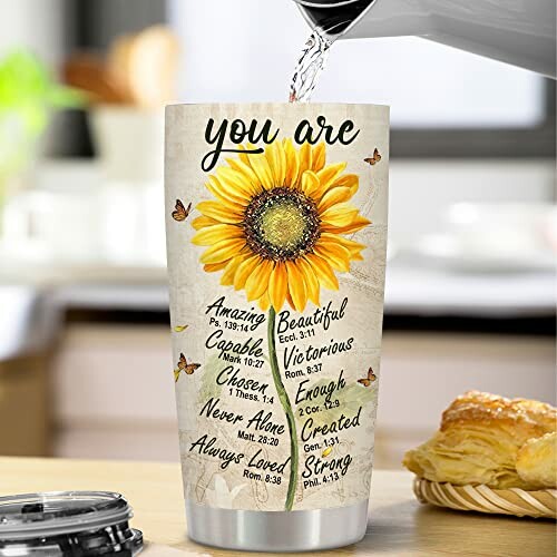 Tumbler with sunflower and motivational words being filled with water.