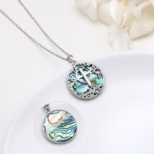 Tree of life pendant with abalone shell on a chain.