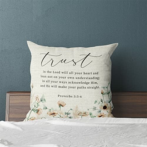 Decorative pillow with Proverbs 3:5-6 verse on a bed.