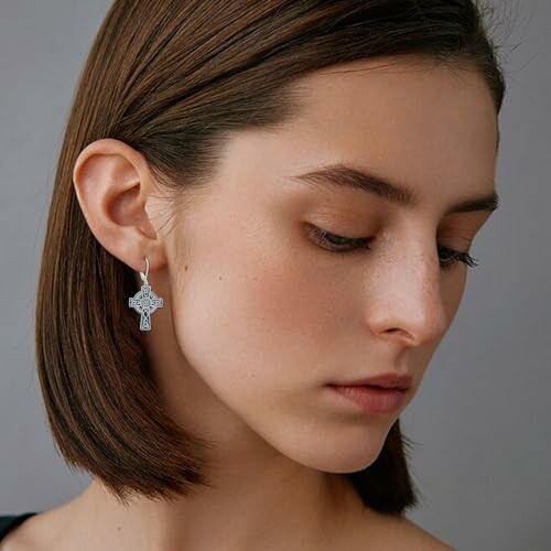 Woman with short hair wearing a cross earring