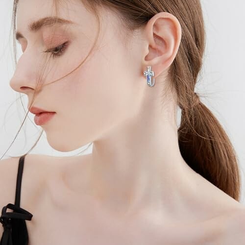 Profile of a woman wearing a cross-shaped earring.