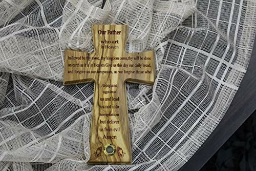 Wooden cross with the Lord's Prayer on a fabric background.