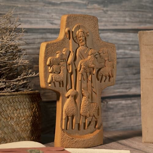 Wooden cross with religious carving of shepherd and sheep.